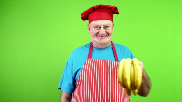 Starszy Kucharz Fartuchu Wskazując Palcem Banany Macierzyste Zatwierdzić Zdrowy Styl — Wideo stockowe