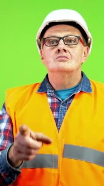 Kızgın olgun ustabaşı, profesyonel olmayan beceriksiz işçiyi el hareketiyle kovuyor. Olgun yönetici kötü bir çalışanı işaret ediyor ve ayrılmak istiyor. Yeşil ekran. Krom anahtar. Dikey.