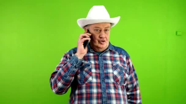 Ein Älterer Mann Mit Weißem Cowboyhut Und Legerer Kleidung Spricht — Stockvideo