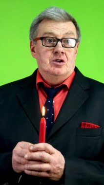 Son sınıf öğrencisi elinde mumla vaaz veriyor, dua ediyor ya da anma konuşması yapıyor. Anılar, ibadet, inanç ve daha iyi bir gelecek için umut. Yeşil ekran. Krom anahtar. Dikey.