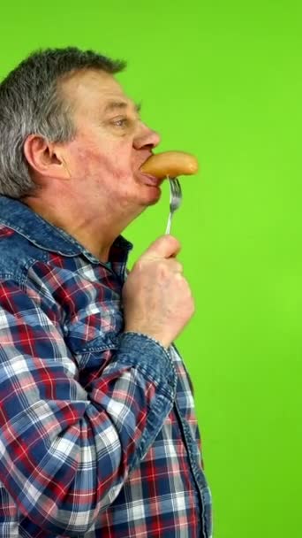 Oudere Man Met Plezier Smakelijke Gekookte Worst Etend Gespietst Vork — Stockvideo