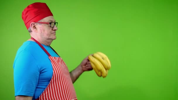 Starszy Kucharz Fartuchu Wskazując Palcem Banany Macierzyste Zatwierdzić Zdrowy Styl — Wideo stockowe