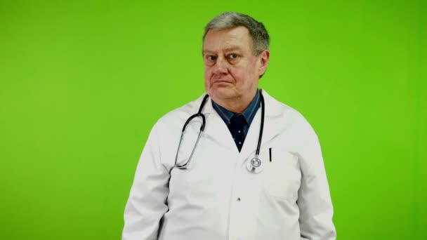 白いコートの不満を持った医師は ノーと言い カメラを見ている不承認に署名します 成熟した医師は否定し 拒否し 反対する グリーンスクリーン クロマキー — ストック動画