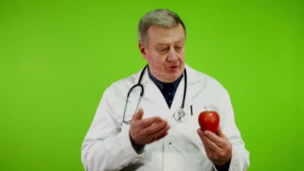 Positive Senior Doctor Shows Ripe Apple Talks Benefits Gives Fruit — Stock Video