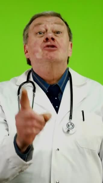 白いコートの怒っている上級医師は 彼の手を振り そして大声で誓います 彼の腕を振る成熟した薬は不満を抱き 感情的に憤慨して叫びました グリーンスクリーン クロマキー バーティカル — ストック動画