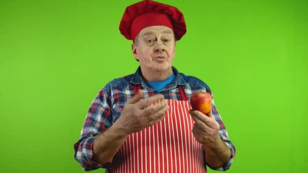긍정적인 요리사는 사과를 보여줍니다 이익에 이야기하고 과일을 제공합니다 성숙한 요리사 — 비디오