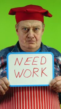 Kırmızı önlüklü kıdemli şef el ele tutuşuyor. Yazı üzerinde çalışmak gerekiyor. Olgun aşçı, işsizlik ve kriz zamanlarında iş arıyor. Yeşil Ekran. Krom anahtar. Dikey.