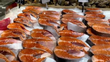 Taze dilimlenmiş çiğ somon parçaları balık pazarında buzdolabı tezgahında buzda satılıktır. Süpermarketin deniz ürünleri bölümünde satılan lezzetli ve sağlıklı kırmızı balıklar. Kapat..