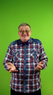 Gözlüklü tuhaf bir adam kameraya bakıyor başını sallıyor ve evet diyor. Olgun bir adamın olumlu cevap vermesi eğlenceli. Yeşil ekran. Krom anahtar. Dikey.