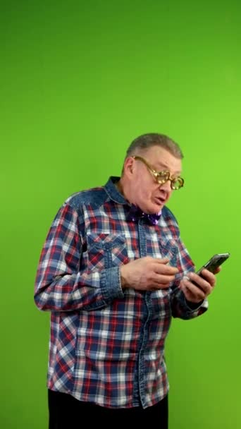 戴著滑稽眼镜的奇怪男人用电话摄像头聊天很有趣 利用技术进行远距离交流 进行远距离交谈 绿色屏幕 垂直方向 — 图库视频影像