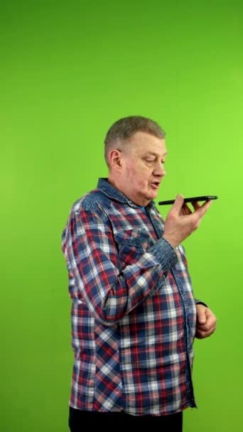 Pria Senior Berpakaian Santai Mencatat Pesan Suara Dengan Speakerphone Menggunakan — Stok Video