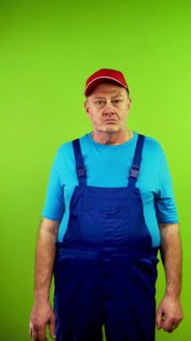 Tulumlu son sınıf öğrencisi kameraya bakıyor ve yüksek sesle hayır diyor. Olgun kişi reddediyor, reddediyor, katılmıyor, kesin olarak karşı çıkıyor. Yeşil ekran. Krom anahtar. Dikey.