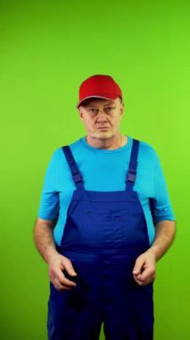 Tamirci yanıtı bilmiyor. Tereddüt ediyor, omuz silkiyor ve avuç içini açıyor. Olgun işçi bilgilerden emin değil, kafası karışık. Yeşil ekran. Krom anahtar. Dikey.