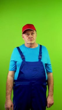 Kıdemli tamirci önemli bir bilgiden beyin patlaması jesti gösteriyor. İşçi gereksiz bilgilerden şaşkına dönmüş ve bunalmış görünüyor. Yeşil ekran, krom anahtar. Dikey.