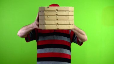 Olgun teslimatçı, pizza kutularını müşteriye verir ve gülümser. Kurye adam, karton kutuya yiyecek siparişi veriyor. Yeşil ekran. Krom anahtar.