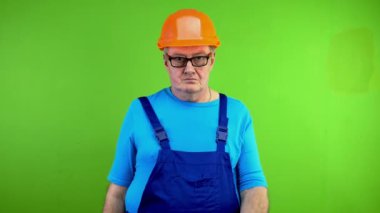 İşçi tulumunda alkol yok işareti var ve kuralları çiğneyen yumruğunu sallıyor. Olgun bir tamirci, sarhoşları işteyken olumsuz etkiler. Yeşil ekran. Krom anahtar.