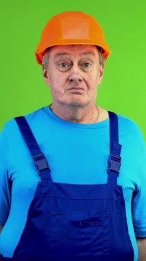 Tamirci yanıtı bilmiyor. Tereddüt ediyor, omuz silkiyor ve avuç içini açıyor. Olgun işçi bilgilerden emin değil, kafası karışık. Yeşil ekran. Krom anahtar. Dikey.