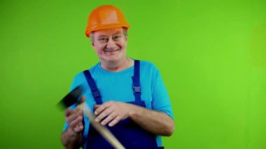 Tulum giymiş kıdemli bir işçi eğleniyor ve enerjik bir şekilde saçma sapan dans ediyor. Elinde tuvalet pompası tutan komik, olgun tamirci hayatından keyif alıyor. Yeşil ekran. Krom anahtar.