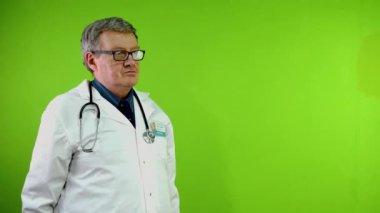 Senior doctor makes perfect gesture and shows thumbs up, everything went smoothly, you are good. Green screen, chroma key.