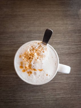Köpüklü Asya latte 'si veya beyaz kahve, yüksek açılı tahta masa manzaralı..
