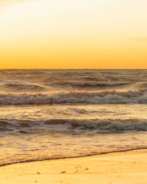 Altın gün batımında deniz dalgalarının güzel manzarası.