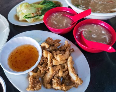 Acı sos ve köpekbalığı yüzgeci çorbasıyla servis edilen bol yağda kızartılmış mürekkep balıkları..