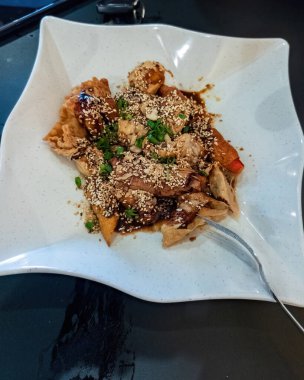 Kızarmış yong tau foo, susamlı tatlı ve baharatlı sosla servis edilir..