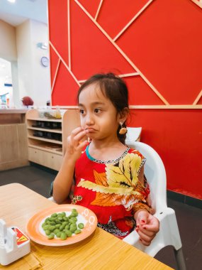 Çocuk Malezya 'daki Sushi restoranında edamame fasulyesi yemekten memnun değil..