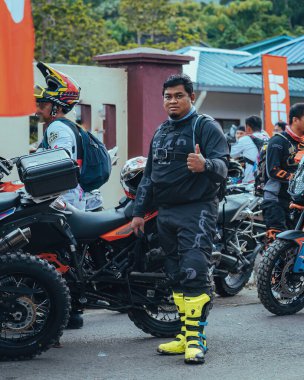 Pahang, Malezya - 24 Eylül 2022 Enduro motosikletçisi antrenman sırasında başlangıç noktasında başparmak hareketi yapıyor.