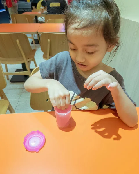 小女孩在餐馆的桌子上玩粉红发亮的黏液 — 图库照片