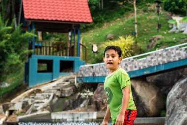 Çocuk ıslak ve havuzun kenarında duruyor..