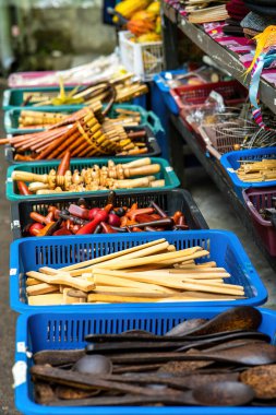 Wooden kitchen utensils in the basket for sale at the market in Malaysia.