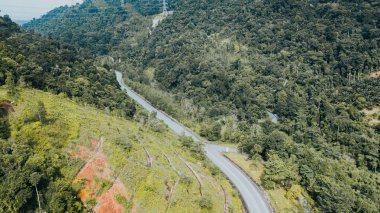 An aerial view of the road across the rainforest mountains in Hulu Selangor, Malaysia.