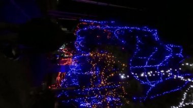 Perak, Malezya - 20 Ekim 2022 Geceleyin renkli LED ışıkları altında ağır çekim yürüyüşü. Dikey video