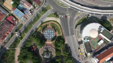 Yolun aşağısında, şehir merkezi çeşme bahçesi olan araçlar yolda ilerlerken tepeden aşağıya doğru hareket ediyor. Malezya 'da. 4K
