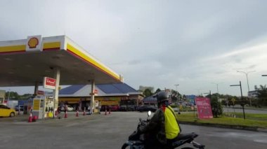  Bangi, Malezya - 22 Kasım 2022 Pan sola, Shell benzin istasyonunun düşük açılı görüntüsü. El bilgisayarı, 4K