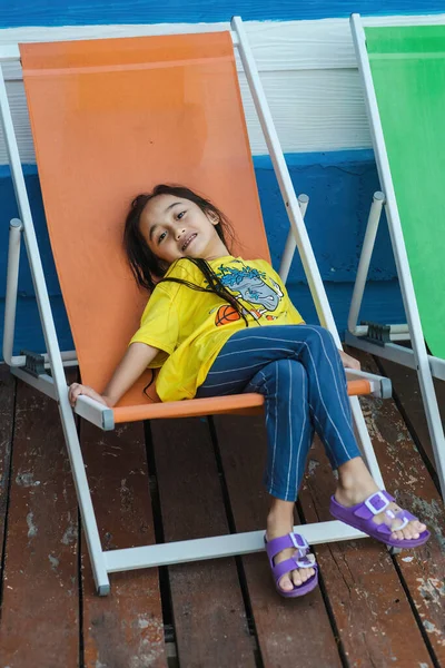 Menina Feliz Sorrindo Enquanto Sentado Assento Praia Resort — Fotografia de Stock
