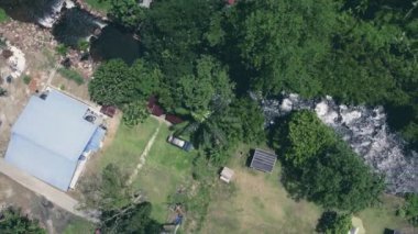 Malezya 'daki köyden akan küçük derenin sağına doğru giden hava manzarası. 4K