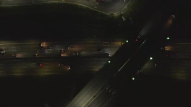 Üst Manzara, geceleri Malezya 'da otoyol kavşağında giden arabaların sağına dön. 4K, Ağır çekim