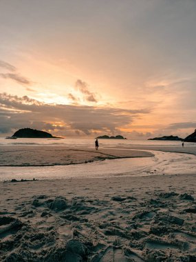 Kumsalda gün doğumu yansımaları. Dokulu ve sulu kumlu sahil.