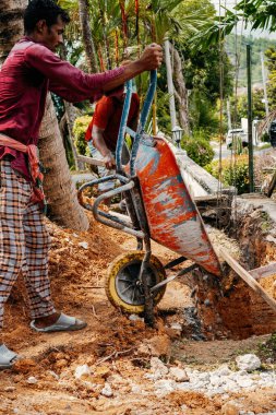 Selangor, Malezya - 21 Ekim 2023 Bir ev yenileme inşaatındaki deliğe beton döken adam.