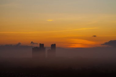 Gökdelen binasının siluetinin yanında altın gün doğumu.