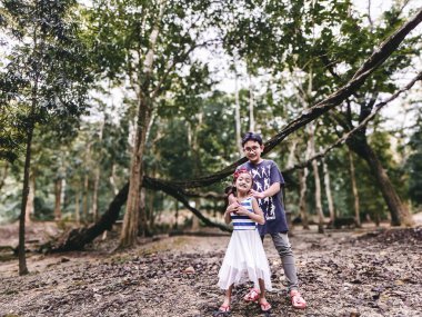 Perlis, Malezya - 6 Ağustos 2022 Erkek ve kız kardeş ormanda eğleniyor.