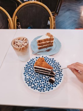 Çay saati için kırmızı kadife ve havuçlu kek ve buzlu latte..