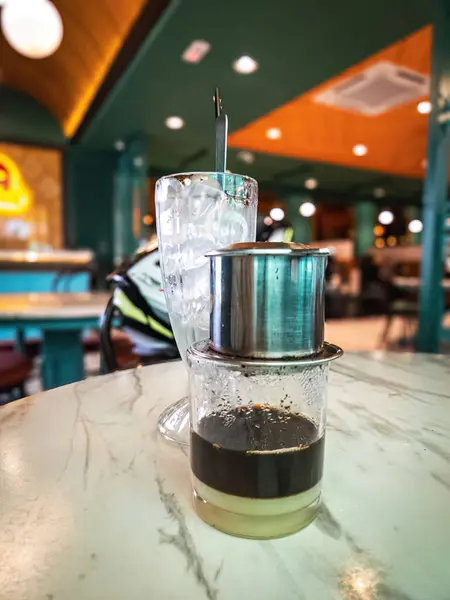 Vietnamese coffee served with the coffee maker on the table at a restaurant.