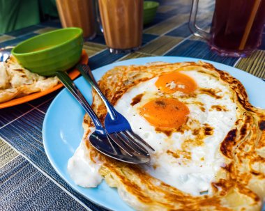 Roti sarang burung, bir pratha kuş yuvasına benziyor ortasında yarı pişmiş yumurta ile Malezya 'da Tarık kahvaltı olarak servis edilir..