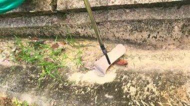 Çöp toplayıcısı kullanarak eski plastik şişeyi kanalizasyondan topluyorsun..