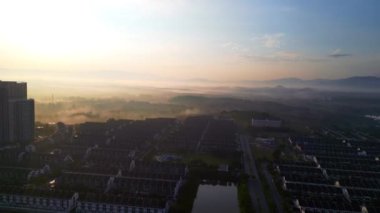 Bangi Bulvarı, Selangor, Malezya 'da sabah sisi ile birlikte apartman yakınındaki altın gün doğumu hava manzarası.