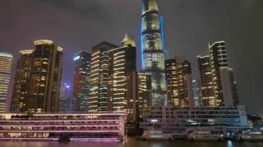 Şangay, Çin - 5 Aralık 2024 Huangpu Nehri 'nin batı kıyısındaki modern ofis binaları gece aydınlandı.