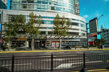 Şangay, Çin - 8 Aralık 2024 Steet 'teki ofis binalarının görüntüsü hareket halindeki arabadan.